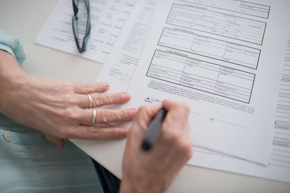 Main qui signe des documents officiels avec un stylo